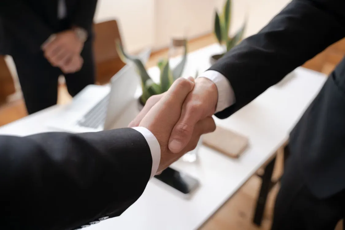 Business handshake representing B2B automated cross-border payment & reconciliation cooperation
